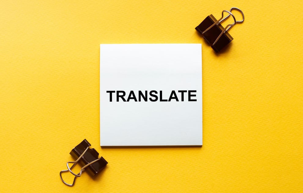 white paper with text Translate on a yellow background with stationery